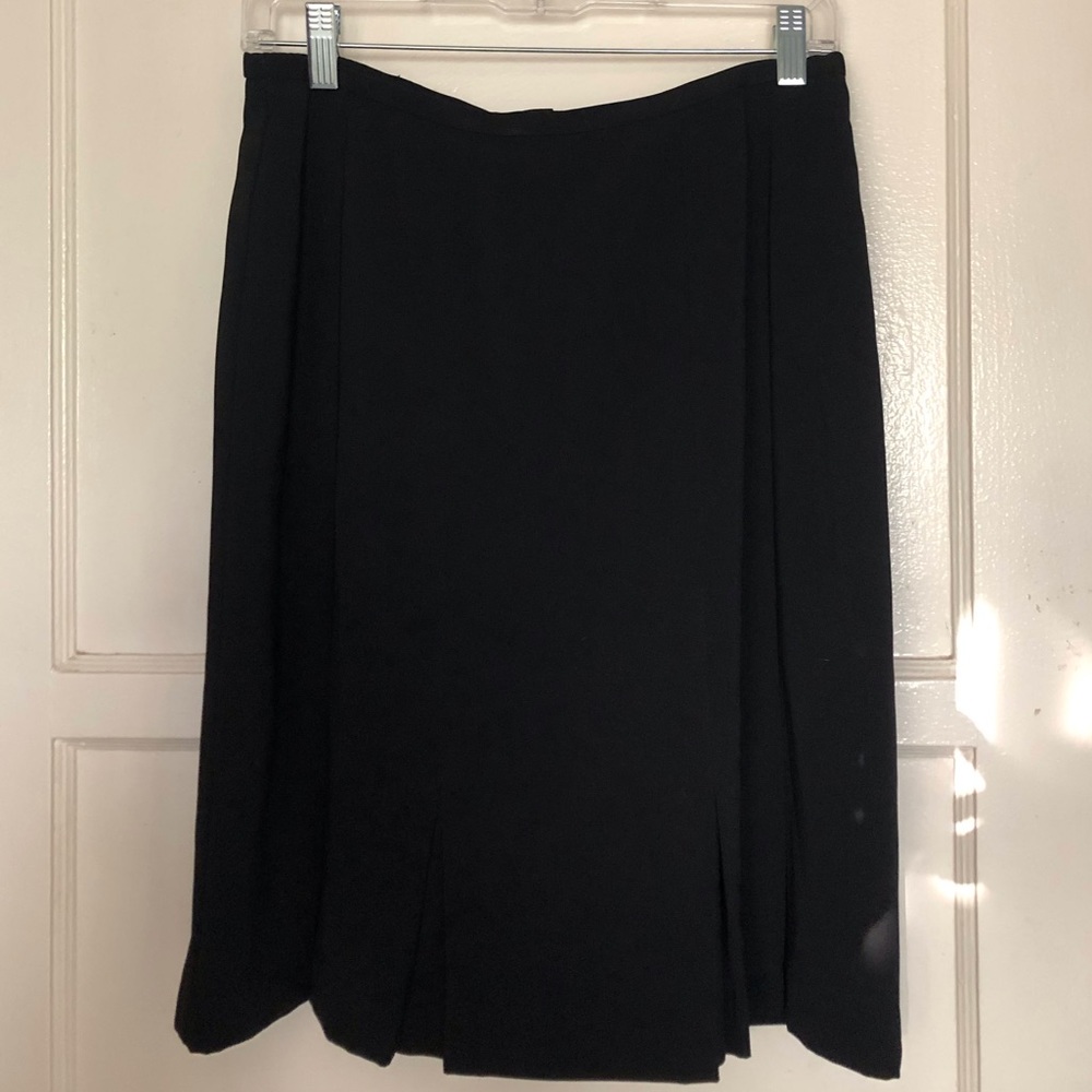 Very cute knee length black skirt with pleats on the bottom edge.